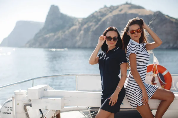 海の岩の近くの高級ヨットで可愛い若い女性たち — ストック写真