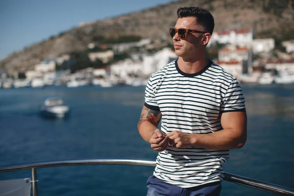 Hombre guapo en un yate en el mar — Foto de Stock