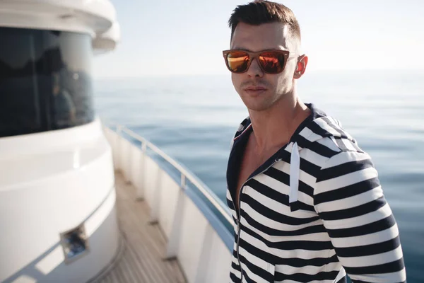 Hombre guapo en un yate en el mar — Foto de Stock