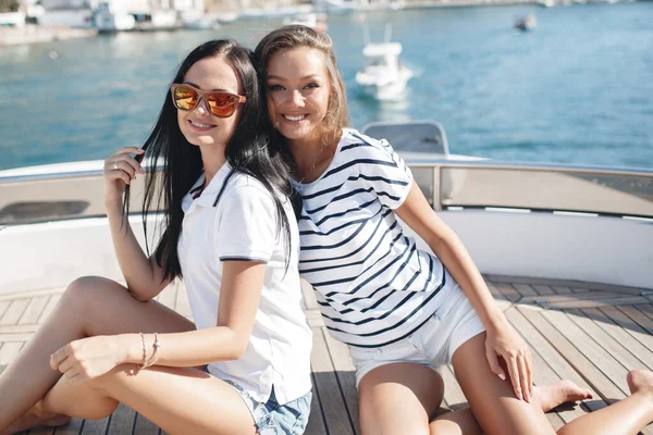 Lindas hembras jóvenes en un yate de lujo cerca de las rocas en el mar —  Fotos de Stock