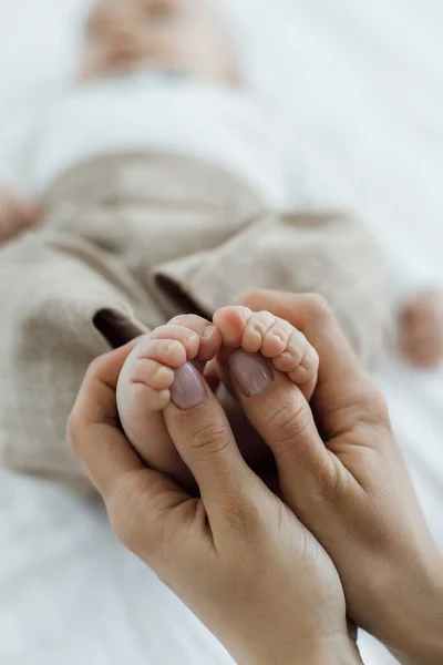 Cute baby feet closeup in mothers hands — стоковое фото