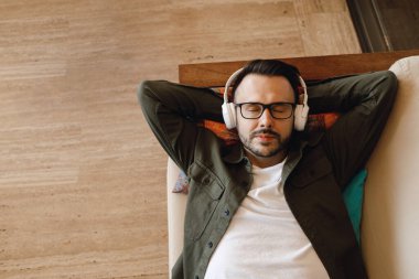 Kulaklıklı yakışıklı adam evde üşüyormuş.