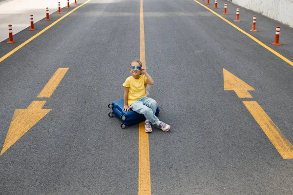 Niedliches kleines Mädchen mit Koffer im Freien — Stockfoto