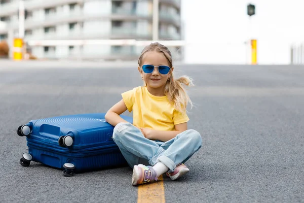 Cute child with suitcase outdoor — стоковое фото