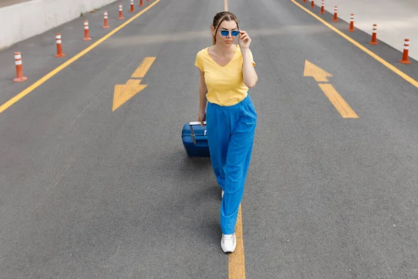 Mujer moviéndose en la carretera con la maleta —  Fotos de Stock