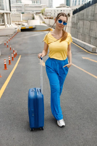 Woman moving on road with suitcase — Photo