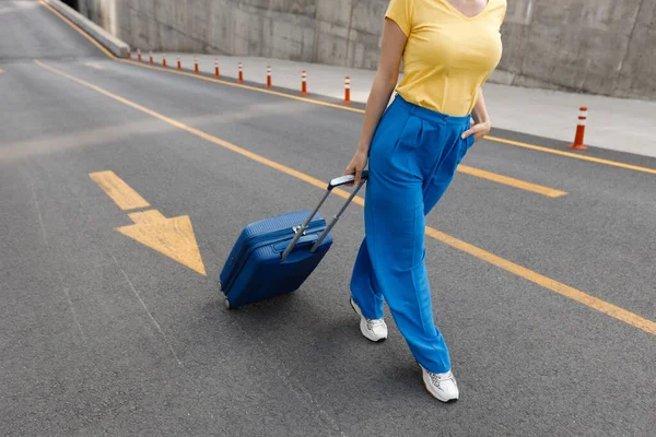 Woman moving on road with suitcase —  Fotos de Stock