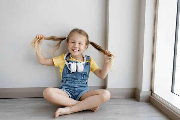 Söt liten flicka hemma med hörlurar — Stockfoto