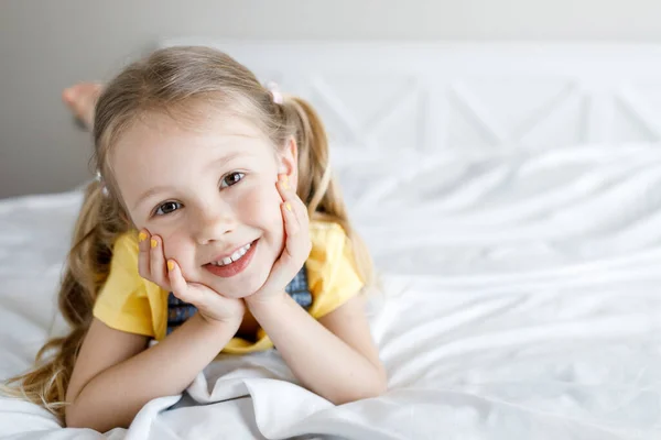 Roztomilá holčička doma v posteli s úsměvem — Stock fotografie