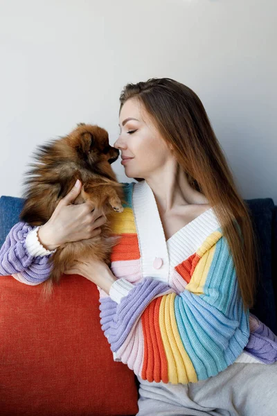 Vacker kvinna med Pommerska hund hemma — Stockfoto