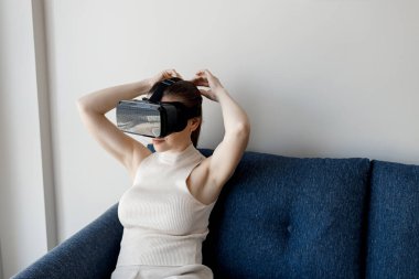 Evde VR gözlük takan kadın.