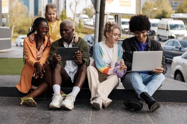 Группа людей с ноутбуком, занимающихся и веселящихся на открытом воздухе — стоковое фото
