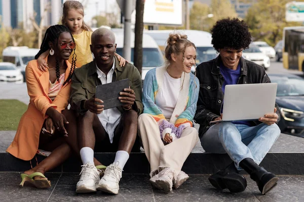Группа людей с ноутбуком, занимающихся и веселящихся на открытом воздухе — стоковое фото