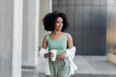 pretty young afro woman with coffee outdoors. High-quality photo