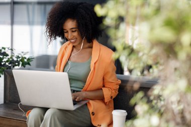 afro woman using laptop outdoor. High-quality photo