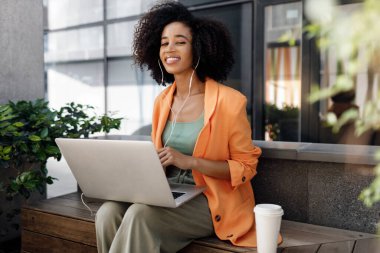 afro woman using laptop outdoor. High-quality photo