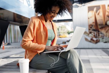 afro woman using laptop outdoor. High-quality photo