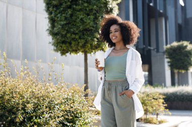 pretty young afro woman with coffee outdoors. High-quality photo