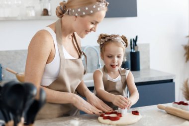 happy kid and mother baking and cooking at home. High quality photo