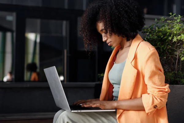 afro woman using laptop outdoor. High-quality photo