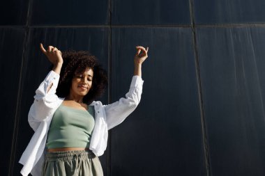 dancing smiling afro woman outdoors. High quality photo