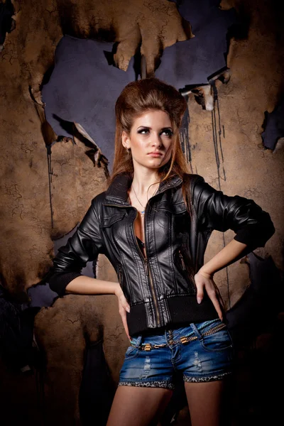 Girl with big hair posing over burned wall background — Stock Photo, Image