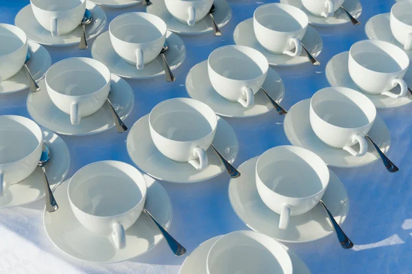 Tazas de té vacías apiladas con cucharaditas en una función sobre ba blanca —  Fotos de Stock