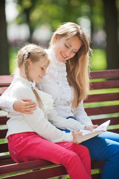 Mom and daughter on a park bench — Stock Photo, Image