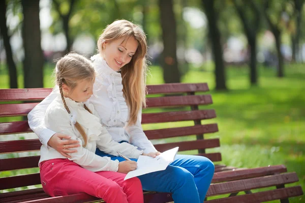 Mom and daughter on a park bench — Stock Photo, Image