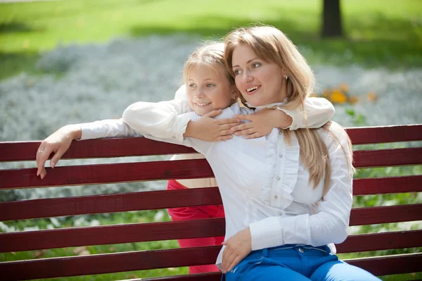 Mãe e filha em um banco de parque — Fotografia de Stock