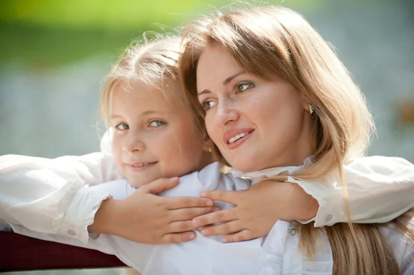 Mãe e filha em um banco de parque — Fotografia de Stock