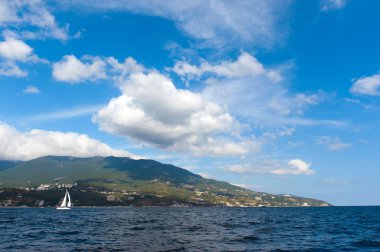 mavi ve sakin denizde küçük yelkenli tekne