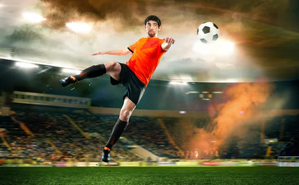 Футболист бьет по мячу на стадионе — стоковое фото
