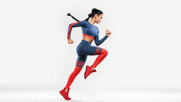 Corredor corriendo aislado sobre fondo blanco. Un fuerte atlético, las mujeres sprinter usando en la ropa deportiva, fitness y motivación deportiva. Ejecutar concepto con espacio de copia. Movimiento dinámico — Foto de Stock