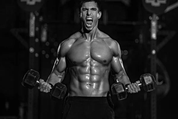 Жорстокий сильний м'язовий культурист спортивний чоловік накачує м'язи з штангою на чорному тлі. Тренувальна концепція бодібілдингу. Копіювати простір для реклами спортивного харчування . — стокове фото