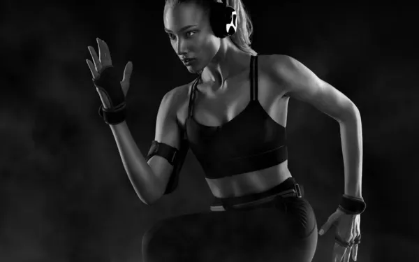 Futás! Erős, fekete hátterű, sportruhában rohangáló nő. Fitness és sport motiváció. Futó koncepció. — Stock Fotó