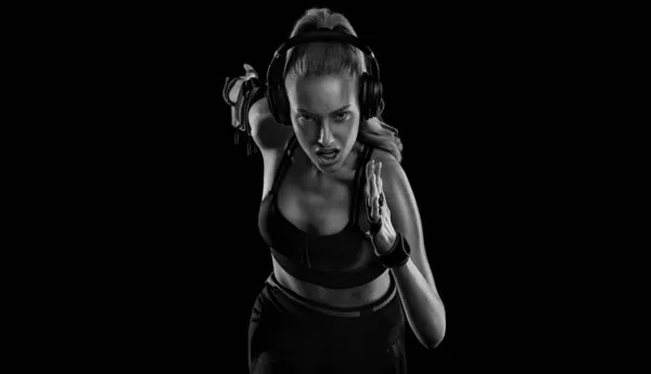 Futó koncepció. Futás! Erős, fekete hátterű, sportruhában rohangáló nő. Fitnesz és sportmotiváció. — Stock Fotó