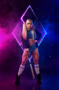 Siyah arka planda beyzbol sopası olan güçlü atletik kadın vücut geliştirici. Spor kıyafetleri giyiyor. Spor ve spor motivasyonu.