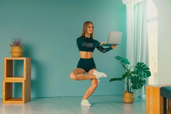 Online trainer. On-line sports. fitness and healthy lifestyle concept. Woman with laptop computer doing plank exercise at home during a pandemic. — Stock Photo, Image