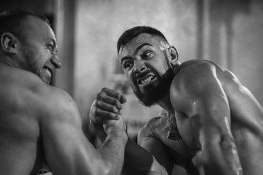 Bilek güreşi. Spor salonundaki iki güçlü sporcu bilek güreşinde yarışıyor. Vücut geliştiriciler, atletizm eğitim odasında bileklikler.