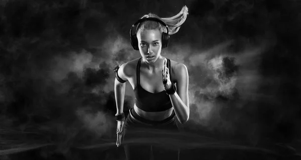 斯普林特跑强壮的女运动员穿着运动服,穿着黑色的背景跑步.健身和运动动机。跑步者概念. — 图库照片