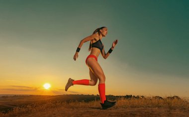 Hızlı koşu. Siyah arka planda koşan güçlü atletik kadın spor kıyafetlerini giyiyor. Spor ve spor motivasyonu. Çalıştırıcı kavramı.