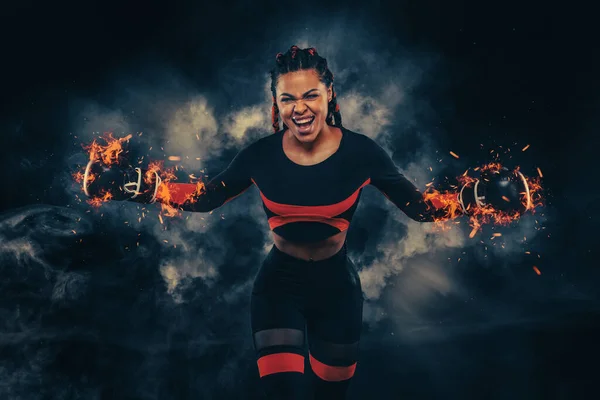 Boxing sport concept. Woman with braids on black background with smoke. Girl sportsman muay thai boxer fighting in gloves in gym. — Stockfoto