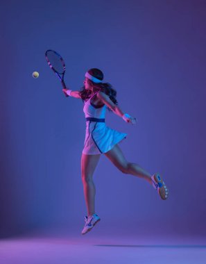 Spor giyim sektöründe raket çalan bir tenisçi. Esmer arka planda oynayan kadın sporcu.