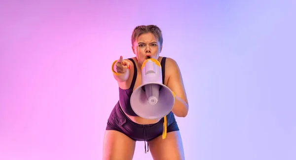 Emocjonalne plus rozmiar kobieta w odzieży sportowej fitness krzyczy za pomocą megafonu. Kwestie społeczne, koncepcja protestu. Dziewczyna mówi do megafonu o nadchodzącej promocji i zniżek w sklepie — Zdjęcie stockowe