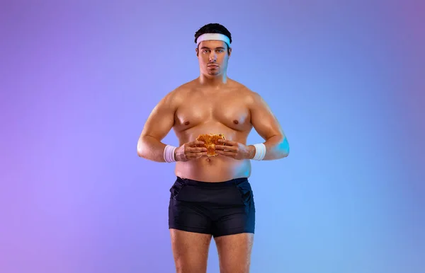 Dicker Mann mit Fast Food. Nicht sportliche Männer trinken und essen Hamburger isoliert auf violettem Hintergrund. — Stockfoto