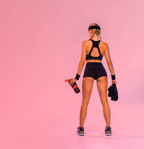 对健身概念的回顾。适合穿着粉色背景服装的女运动员。关于健身主题的社交媒体出版物的想法. — 图库照片