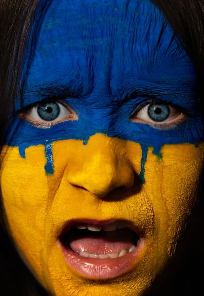 Bandeira da Ucrânia pintada em um rosto no rosto de uma criança adolescente. Guerra entre a Ucrânia e a Rússia. Chorando menina com uma arte de rosto. — Fotografia de Stock