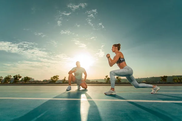 Istruttore e atleta corridore in pista. L'atletica segna il momento in cui gli affondi si esercitano su un cronometro. Fitness trainer e mentee. — Foto Stock