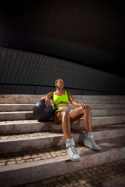 女人们在室外的楼梯上做了一个很重的药物的健身锻炼后休息一下 穿着运动服 体形匀称的性感姑娘 — 图库照片